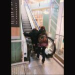 Ride up an escalator in a wheelchair with assistance